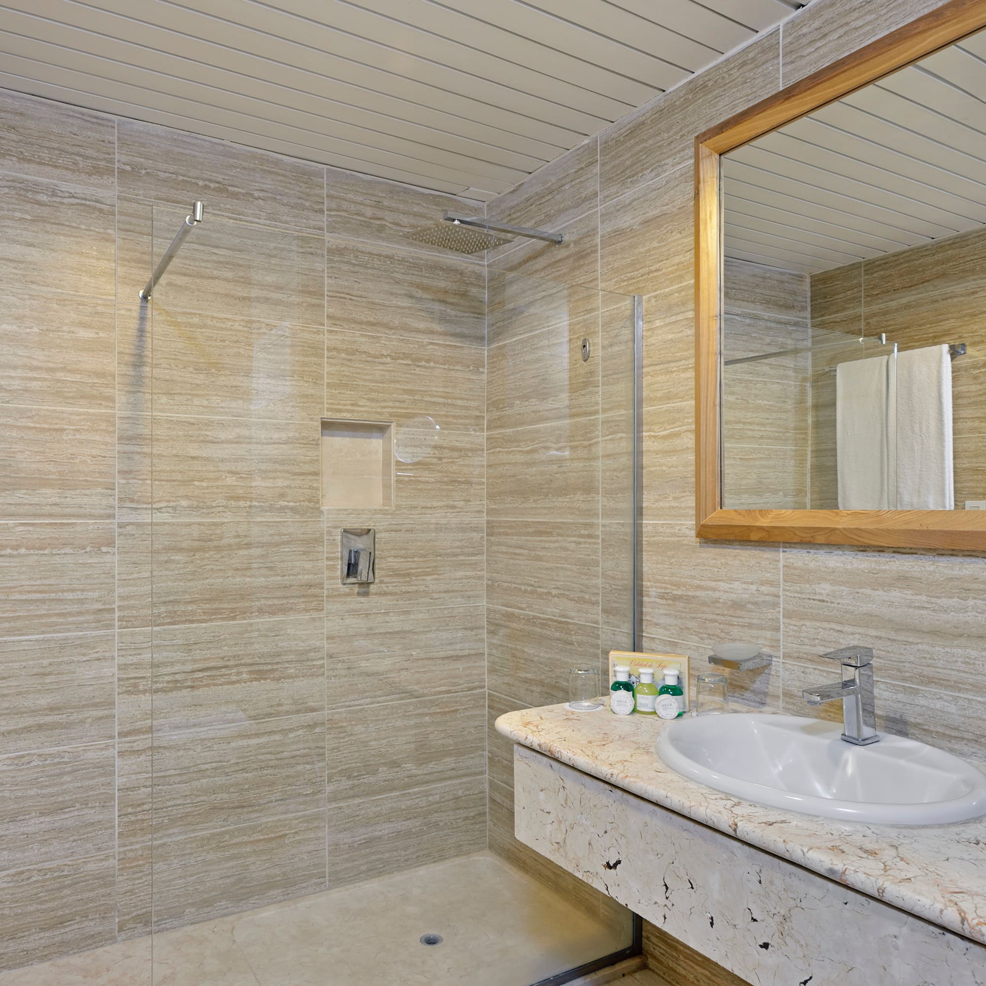 a bathroom with a marble countertop sink and mirror