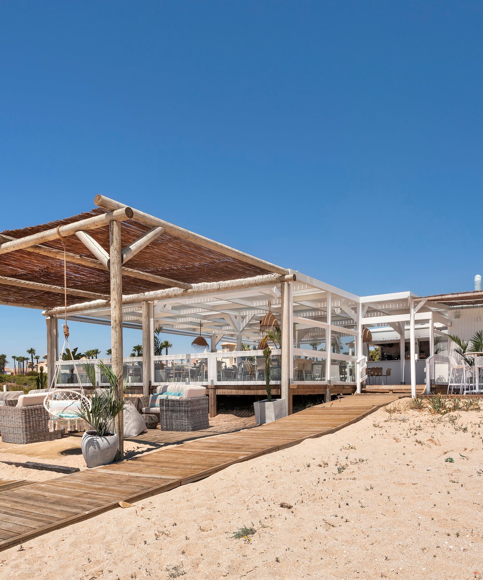 a white building with a wooden structure and a wooden walkway