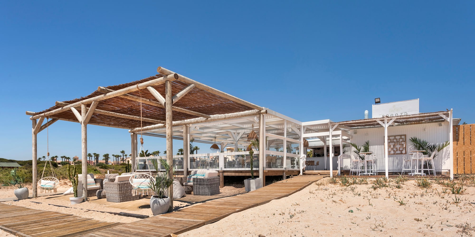 a white building with a wooden structure and a wooden walkway