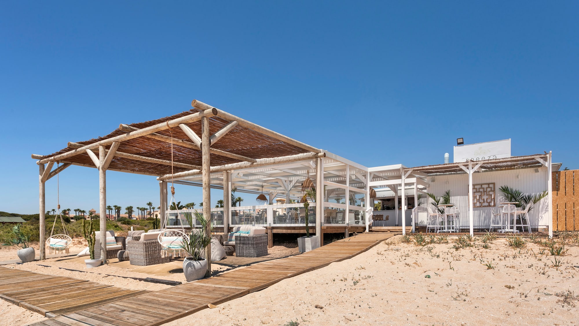 a white building with a wooden structure and a wooden walkway