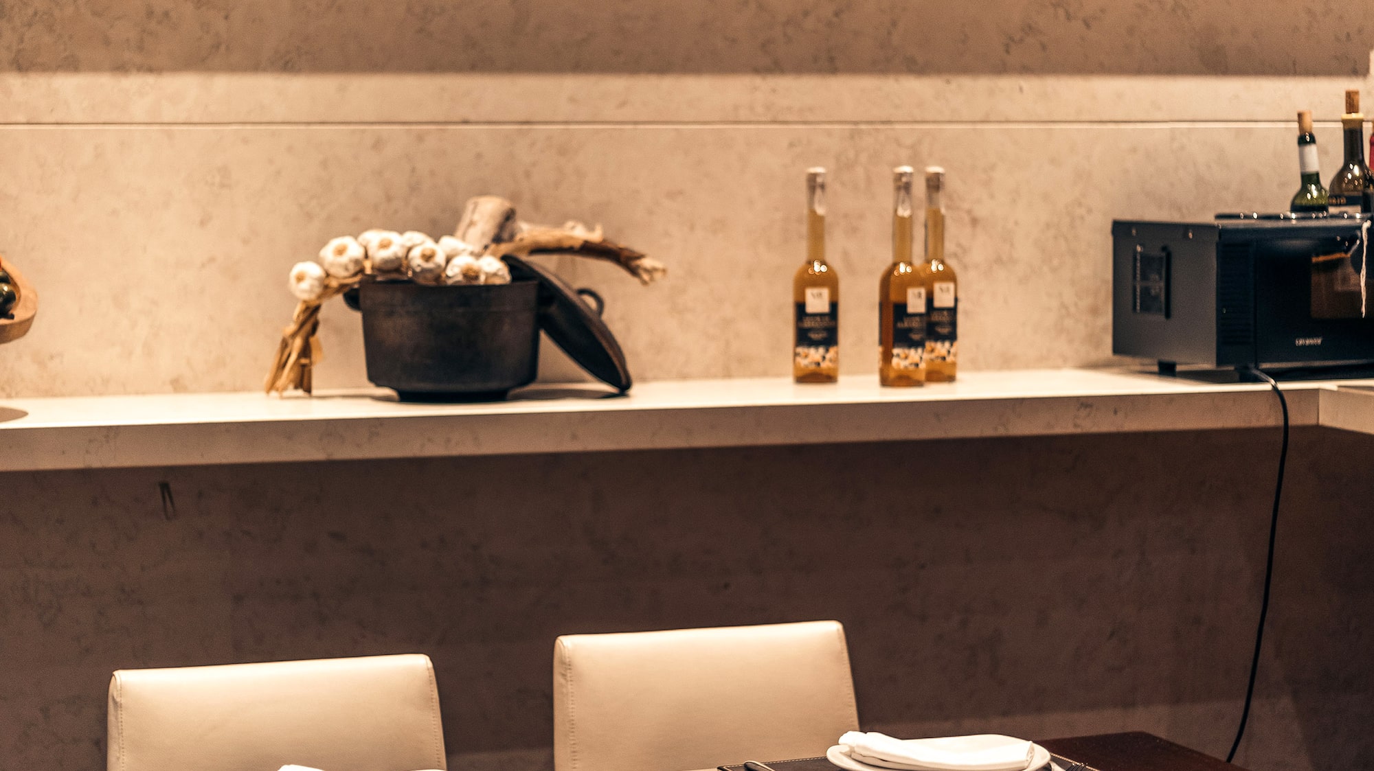 a table with white chairs and a blackboard on the wall