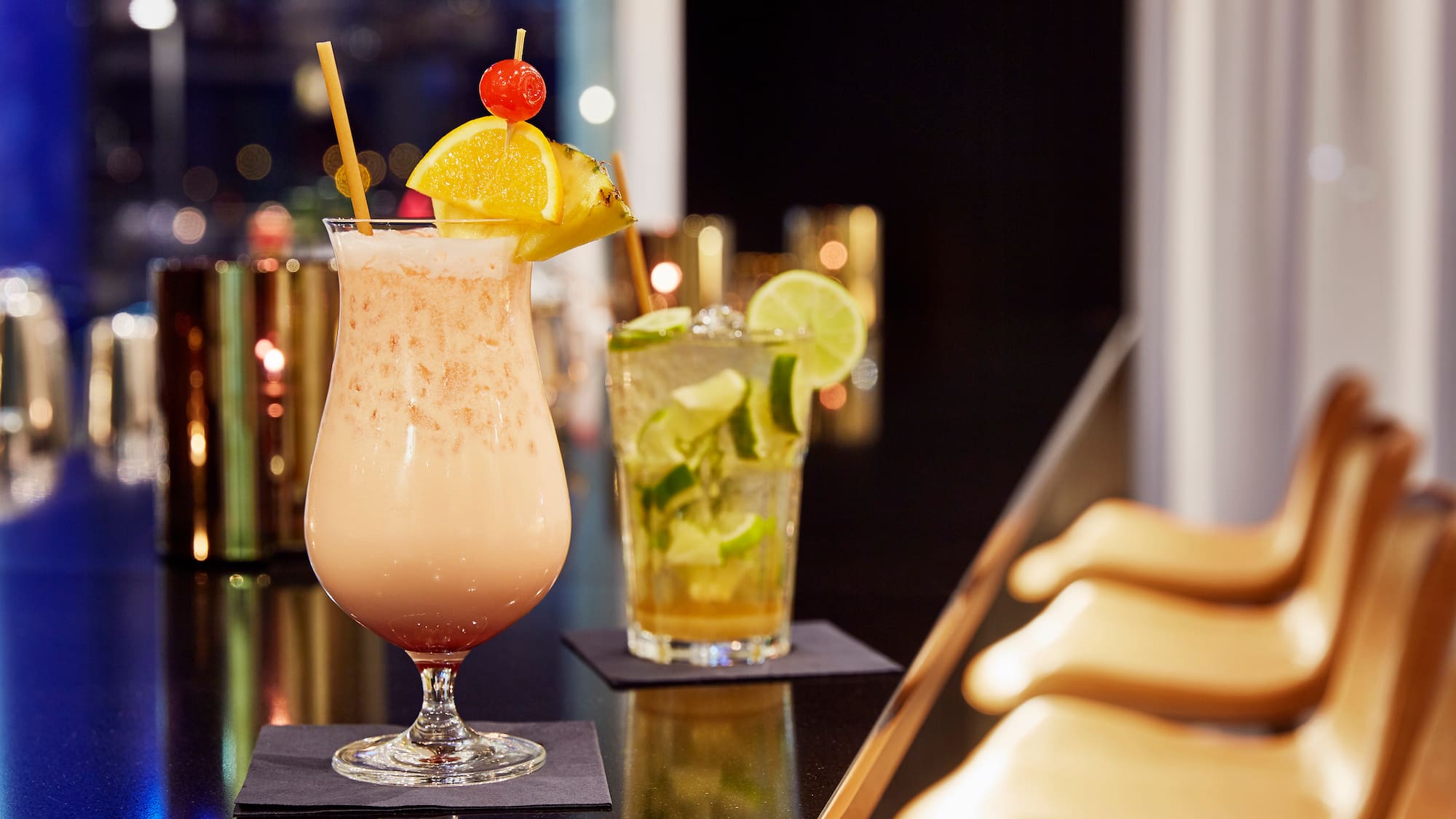 a glass with a drink on a bar