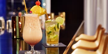 a glass with a drink on a bar