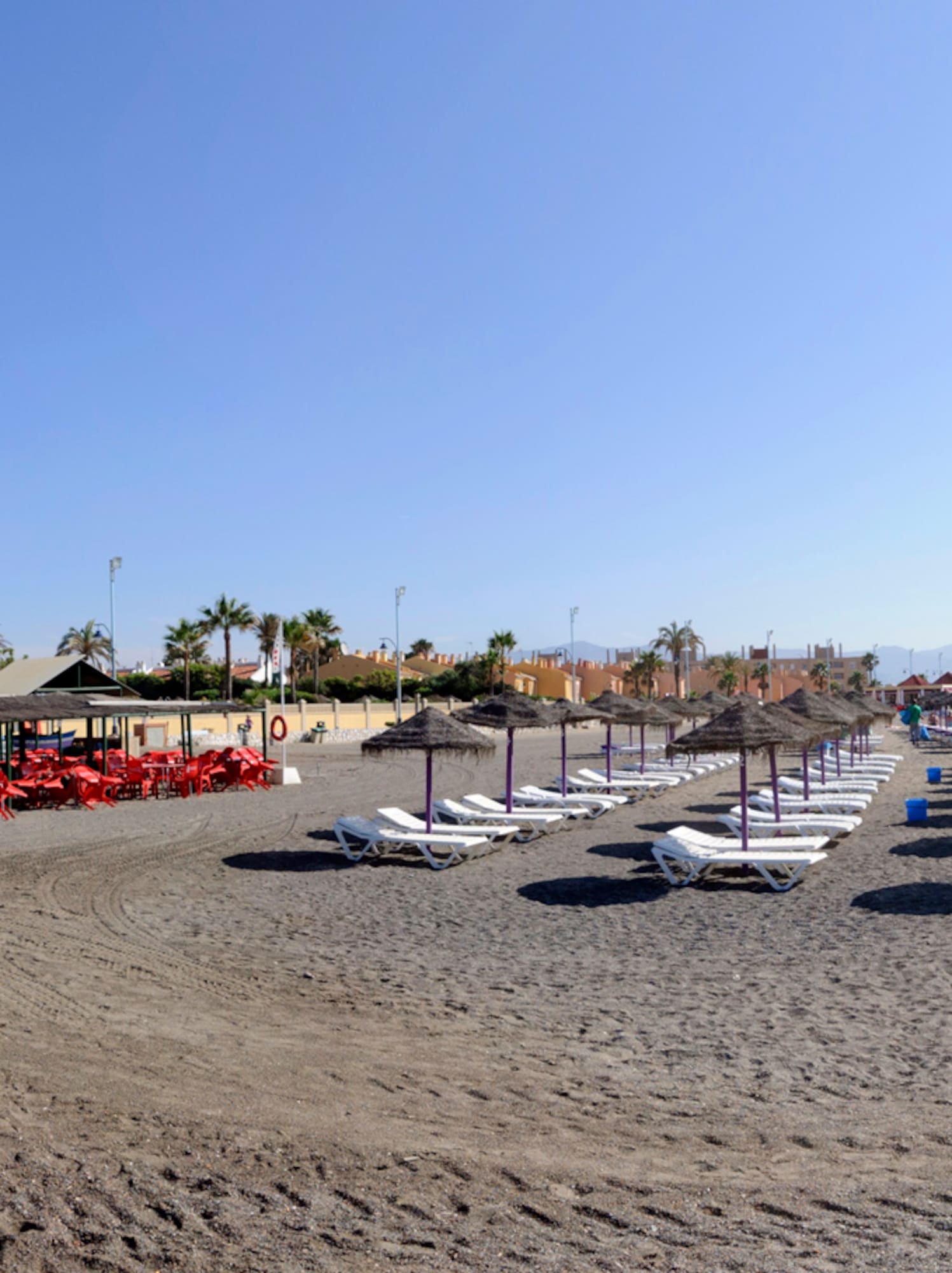 a beach with chairs and umbrellas