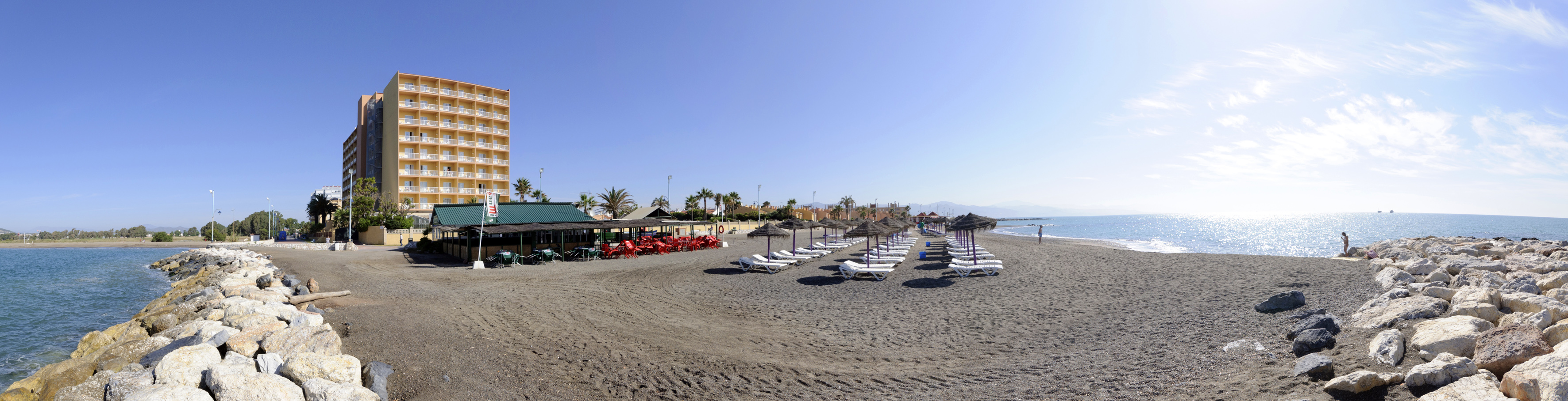 a beach with chairs and umbrellas