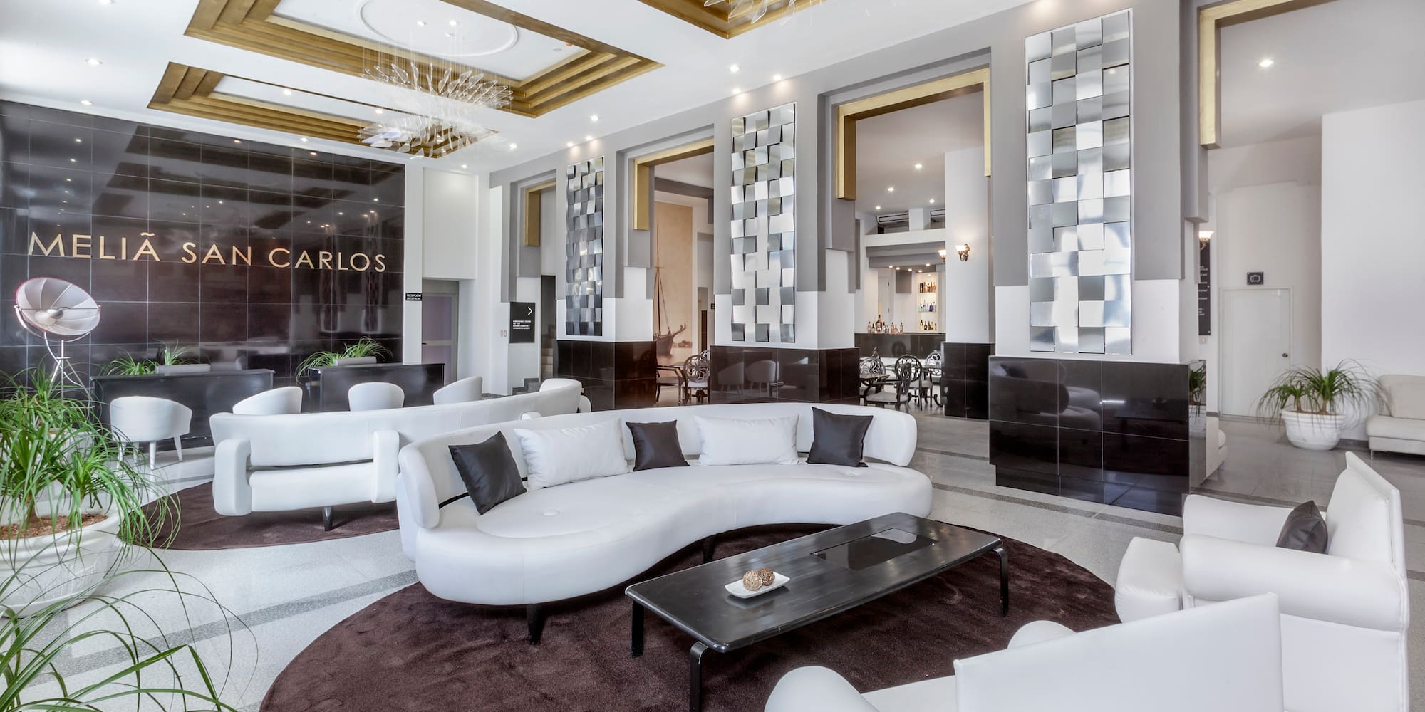 a large room with white furniture and a black table