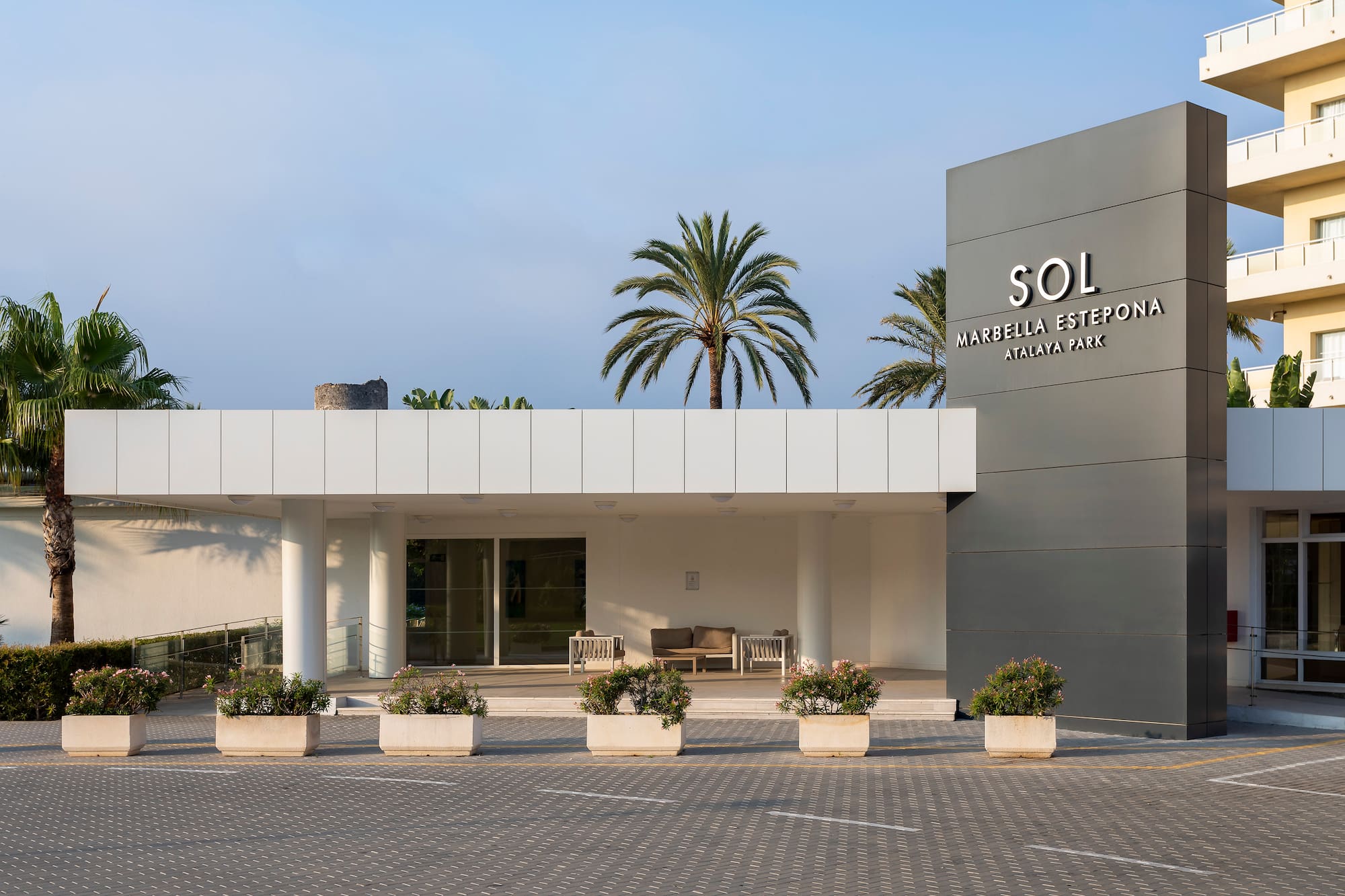 a building with a sign and palm trees