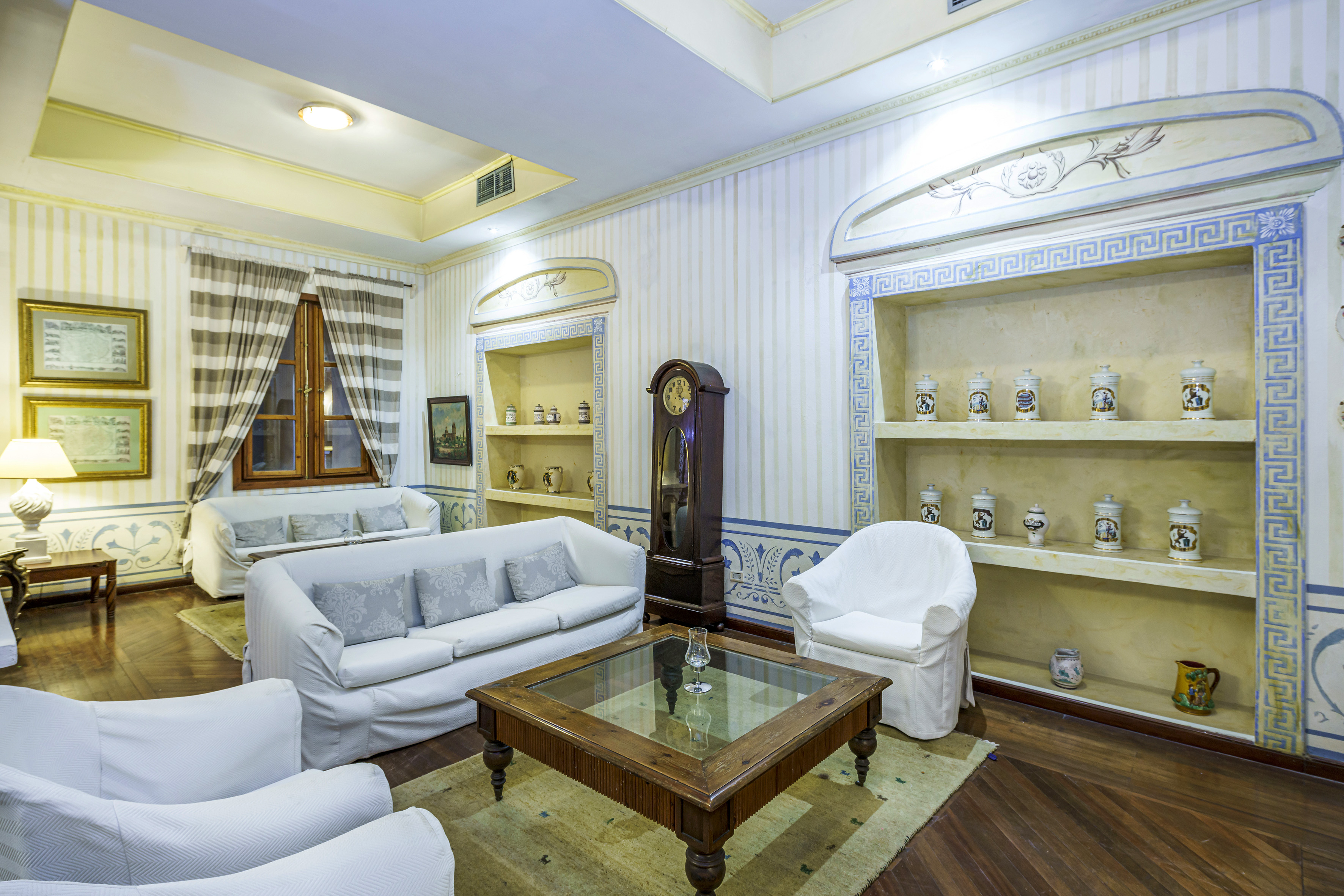 a room with white furniture and a clock