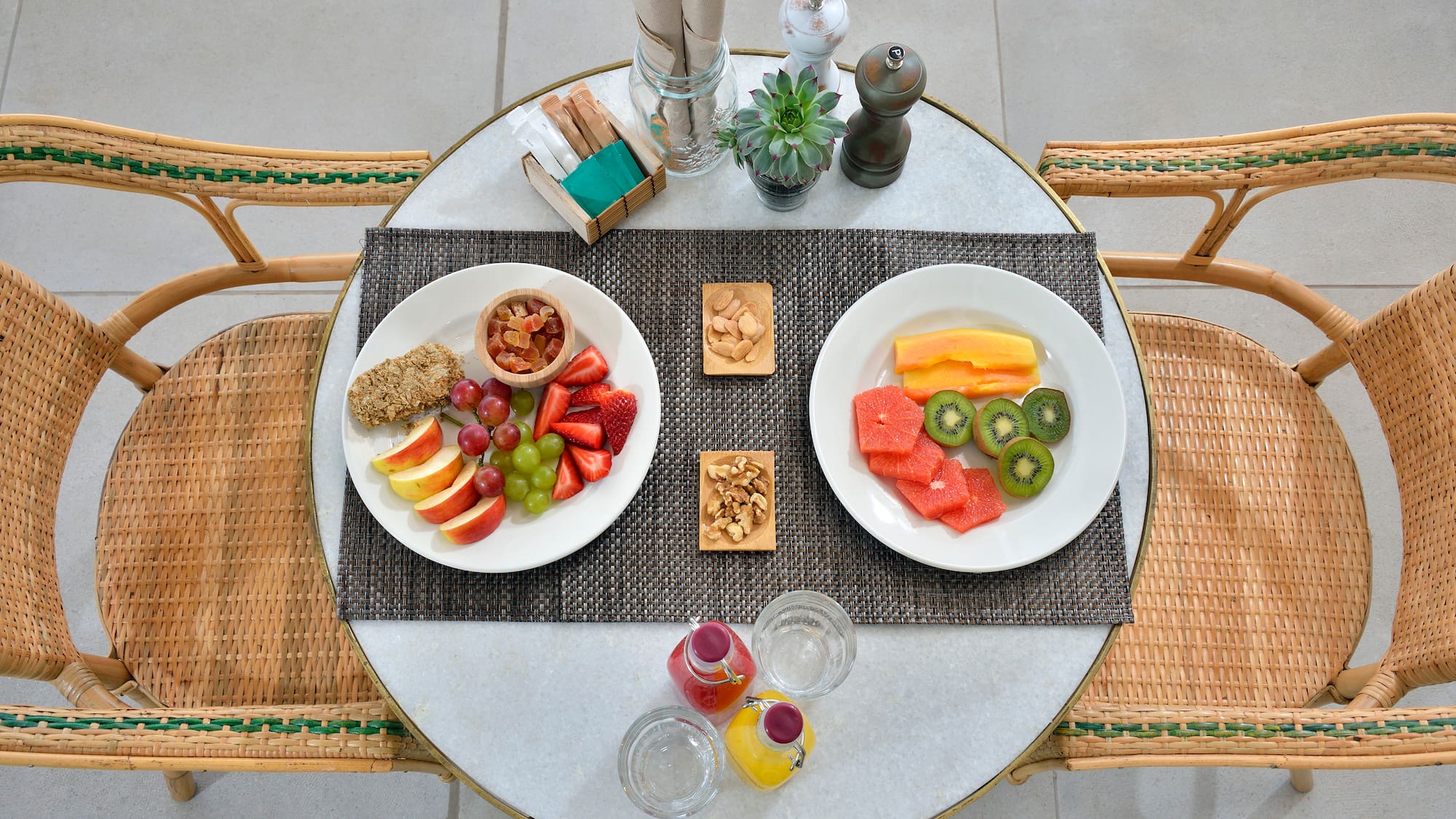 a table with plates of fruit and nuts