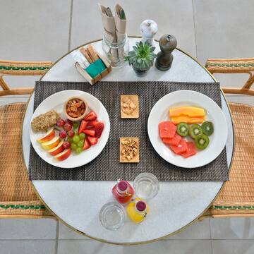 a table with plates of fruit and nuts
