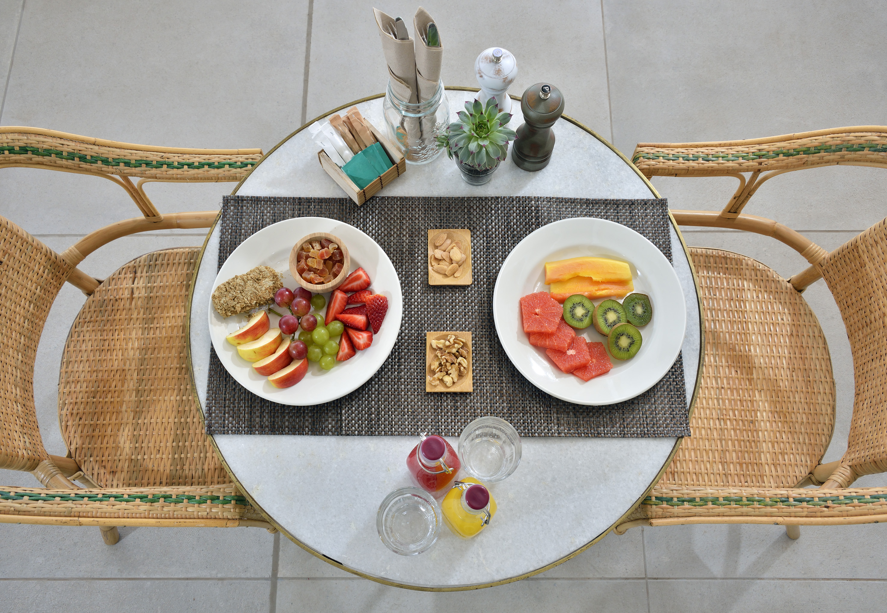 a table with plates of fruit and nuts