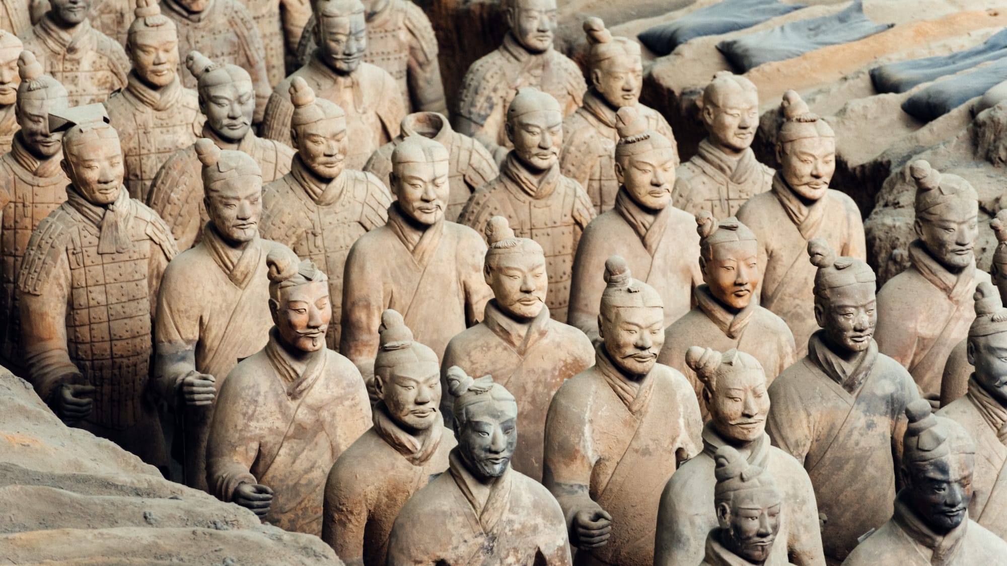 a group of clay statues with Terracotta Army in the background