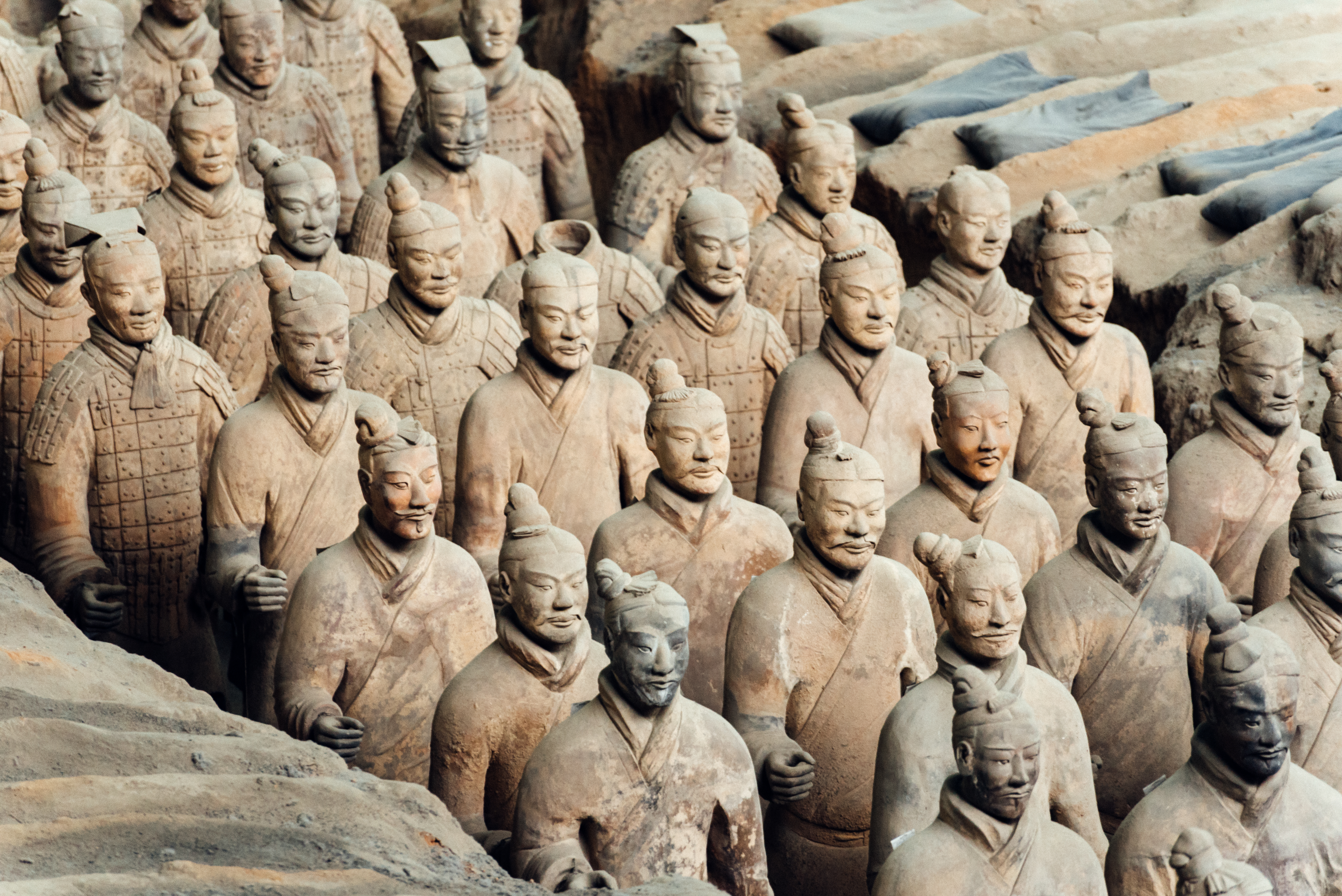 a group of clay statues with Terracotta Army in the background