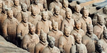 a group of clay statues with Terracotta Army in the background