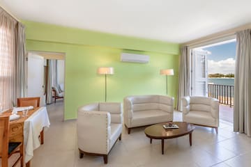 a room with white furniture and a green wall