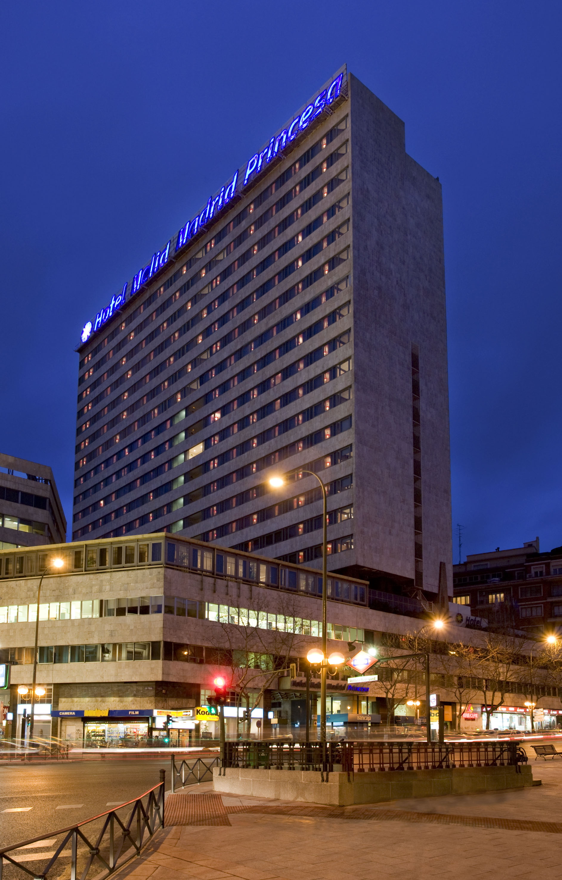 Hotel Meliá Madrid Princesa tower with glowing blue sign, night city.