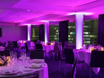 a room with tables and chairs and purple lights