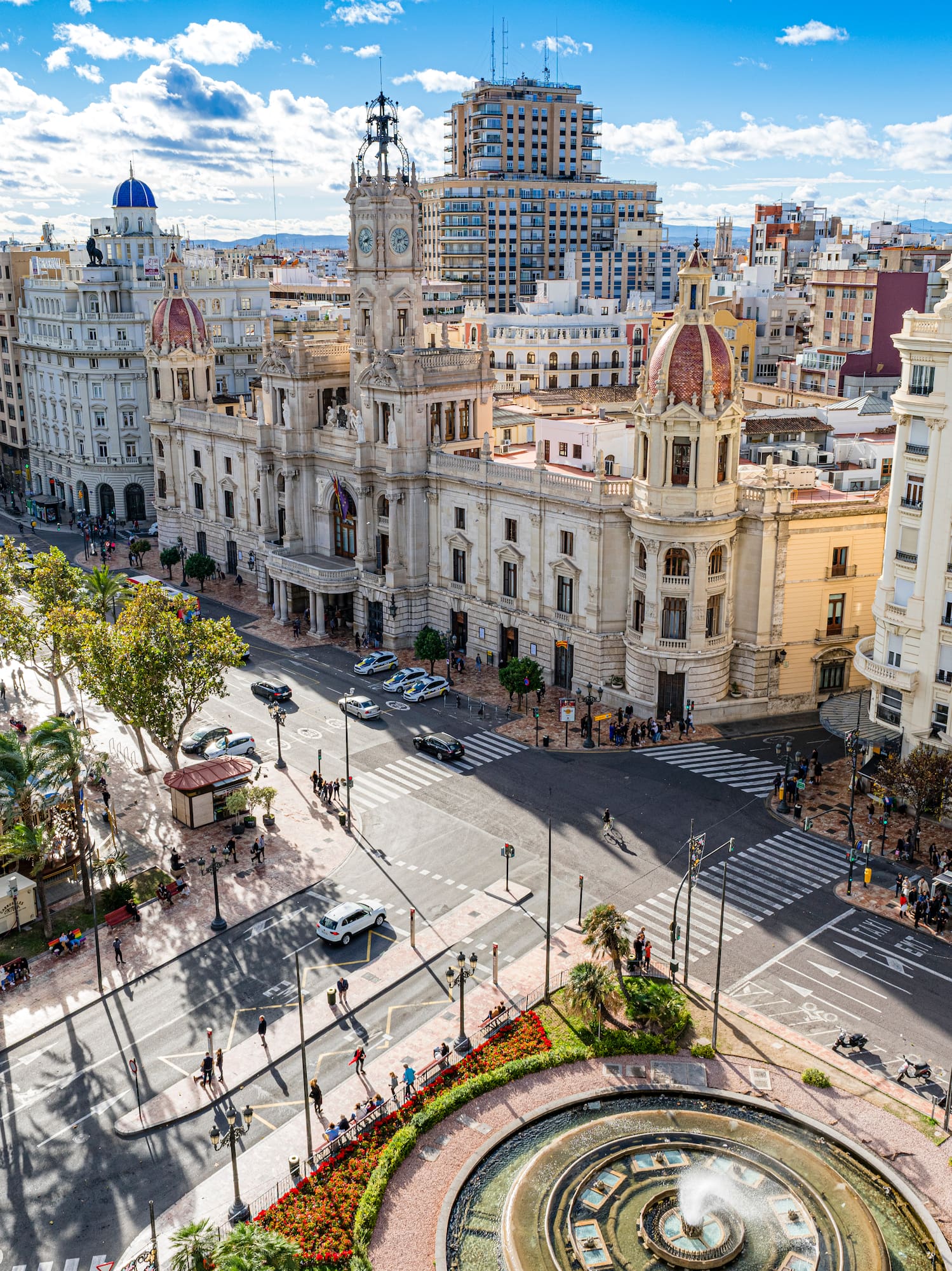 a city street with a fountain and buildings