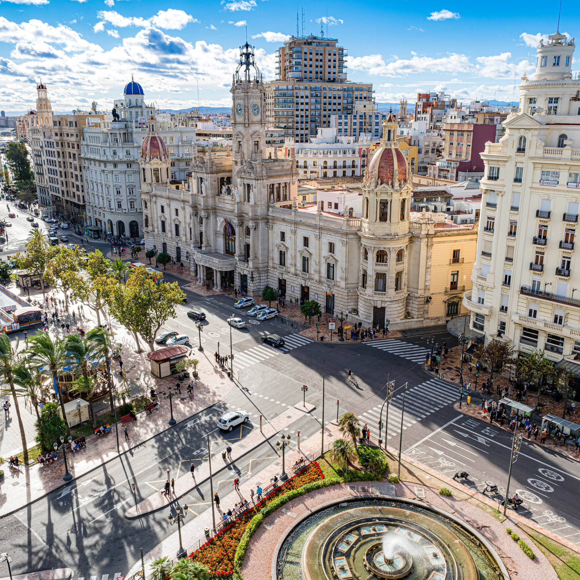 a city street with a fountain and buildings
