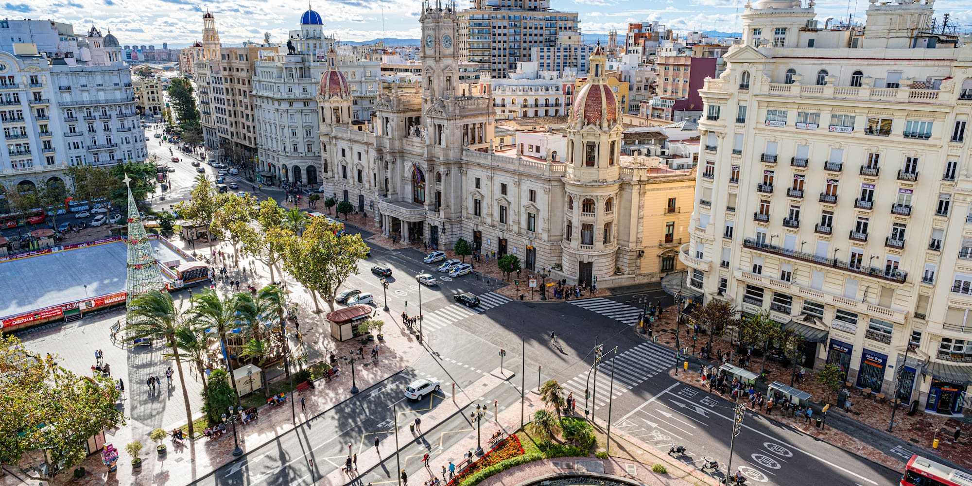 a city street with a fountain and buildings