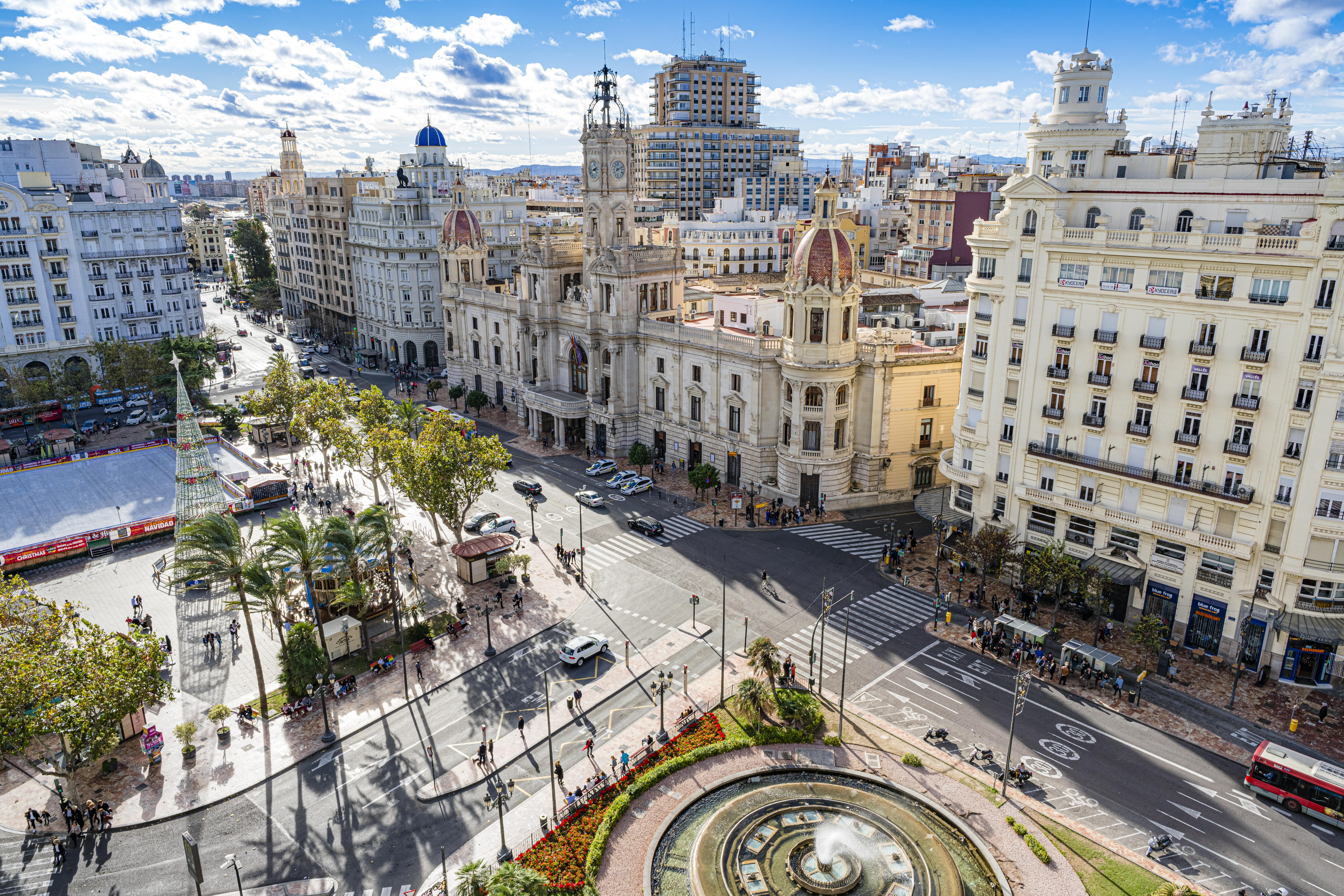 a city street with a fountain and buildings