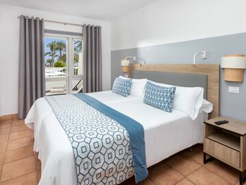 a bed with pillows and a lamp in a room