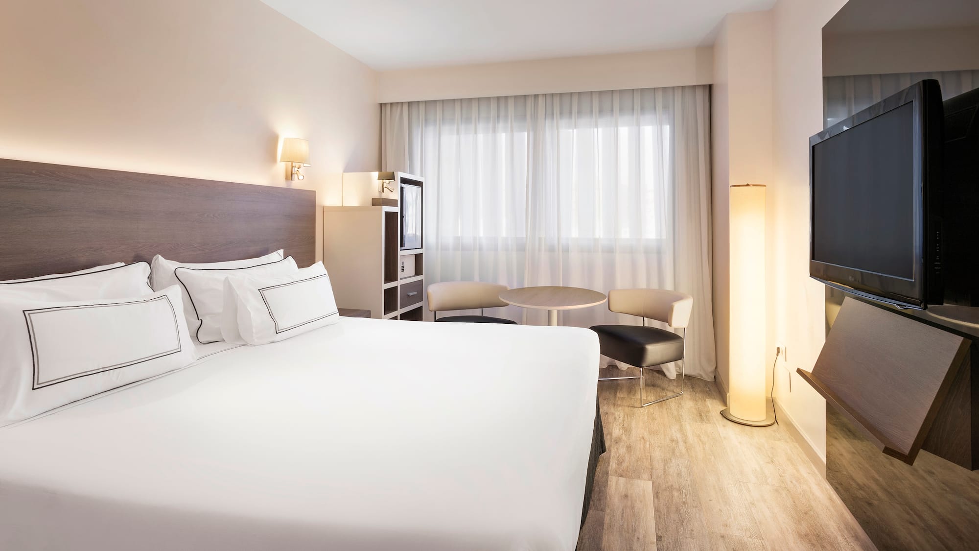 a room with a bed and a television