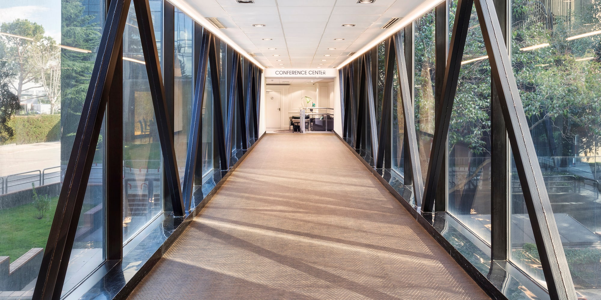 a hallway with glass walls and a large window