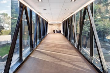 a hallway with glass walls and a large window
