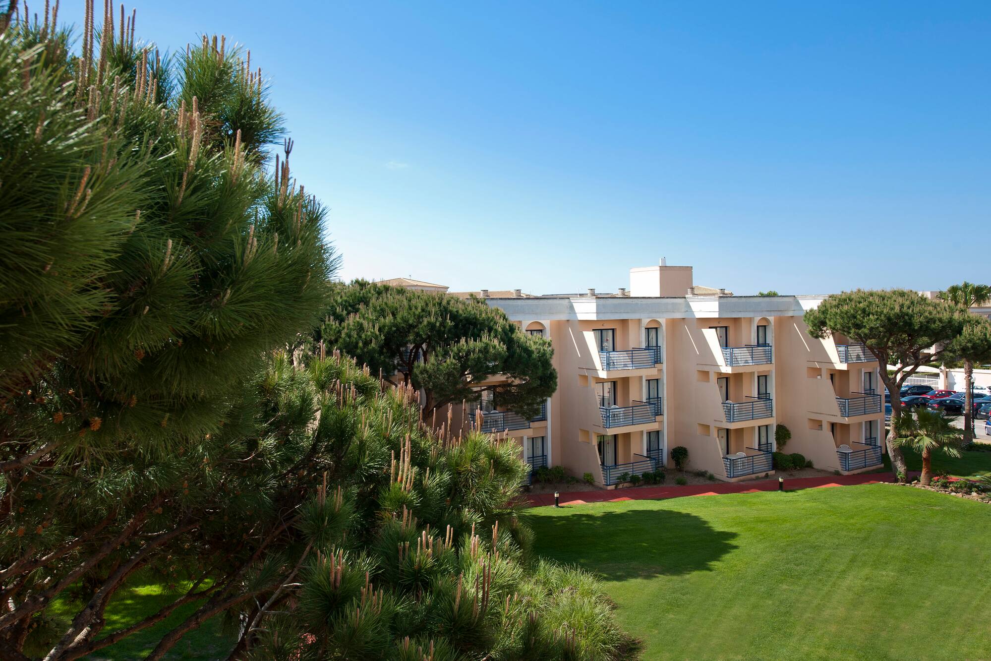 a building with balconies and a lawn