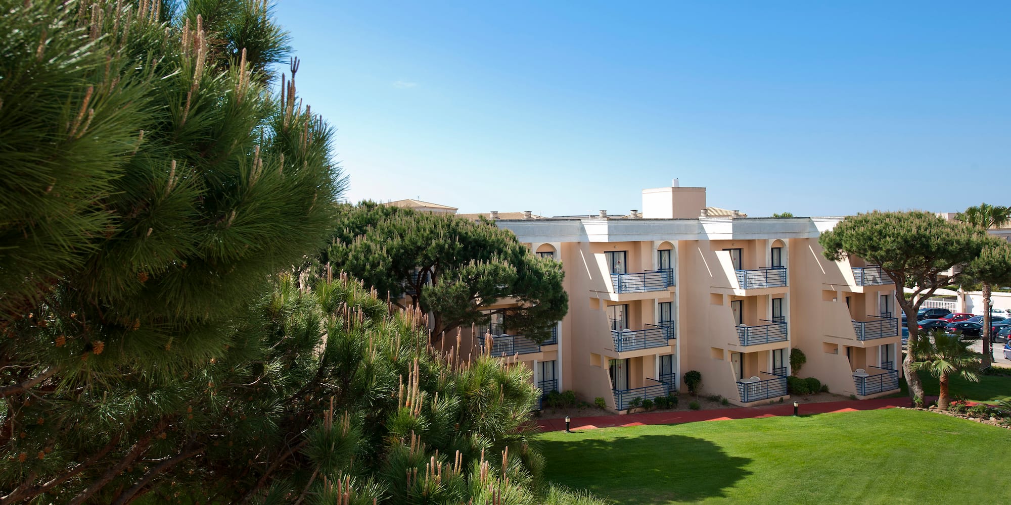 a building with balconies and a lawn
