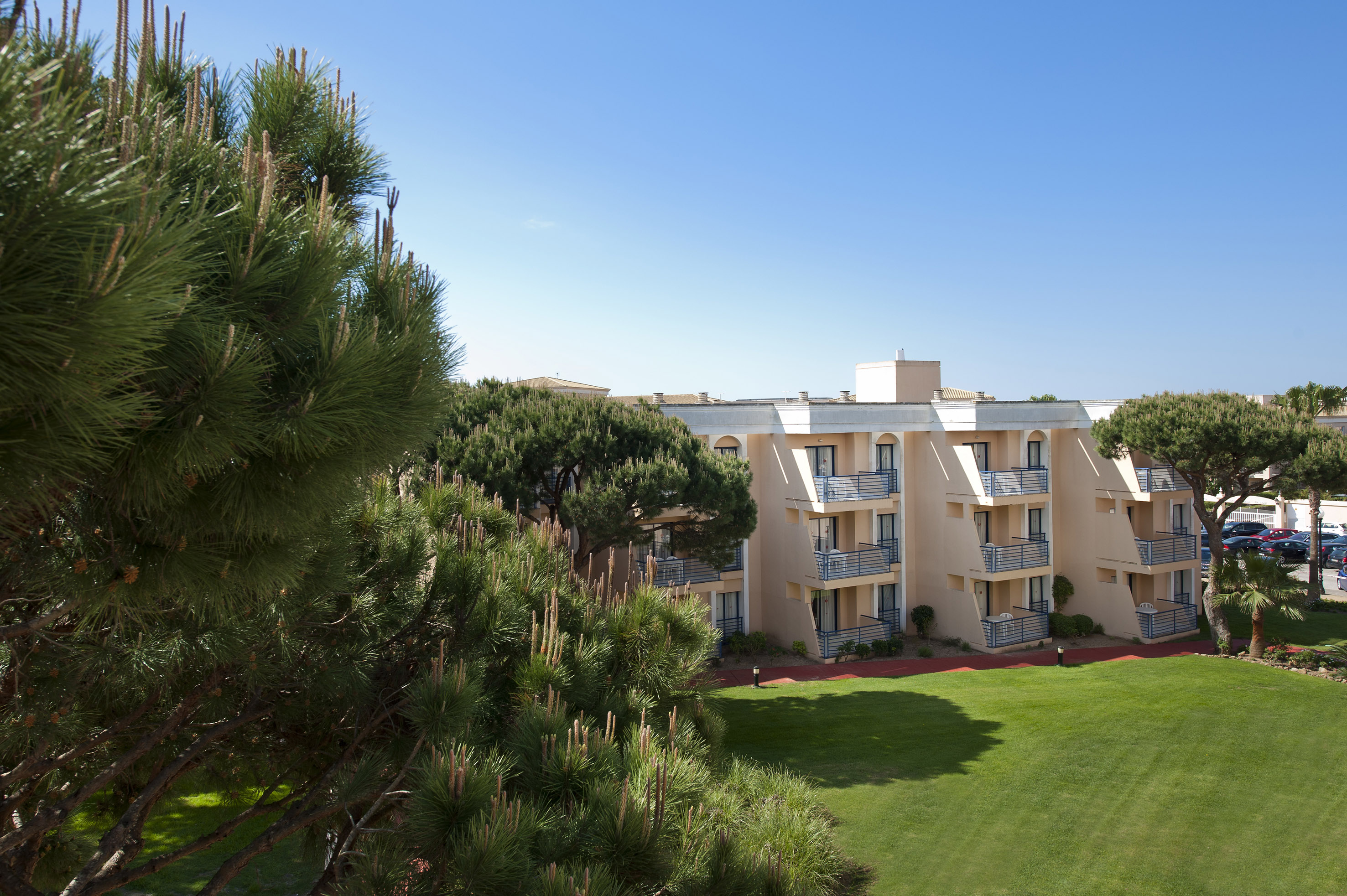 a building with balconies and a lawn