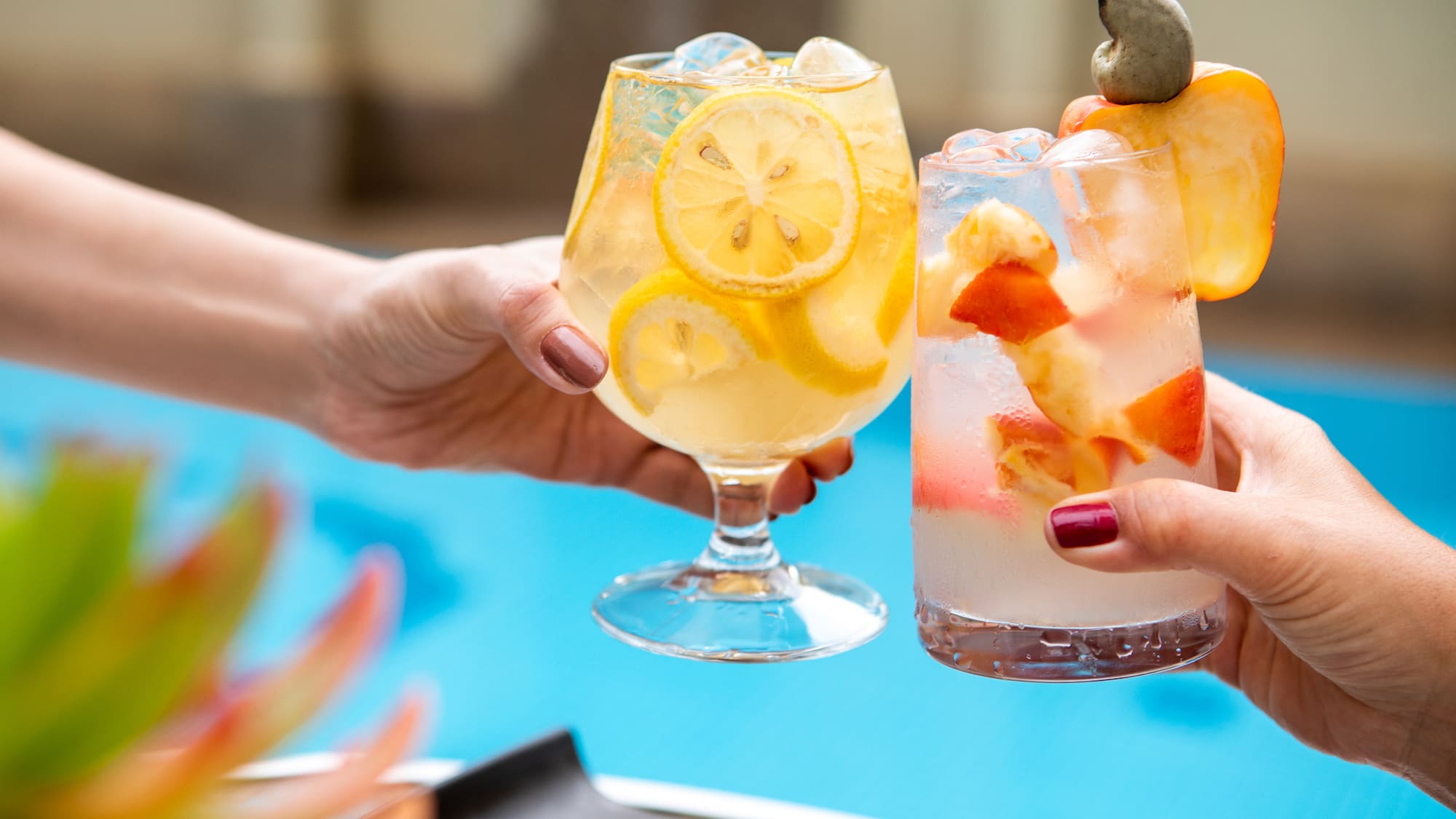 a pair of hands holding glasses with fruit