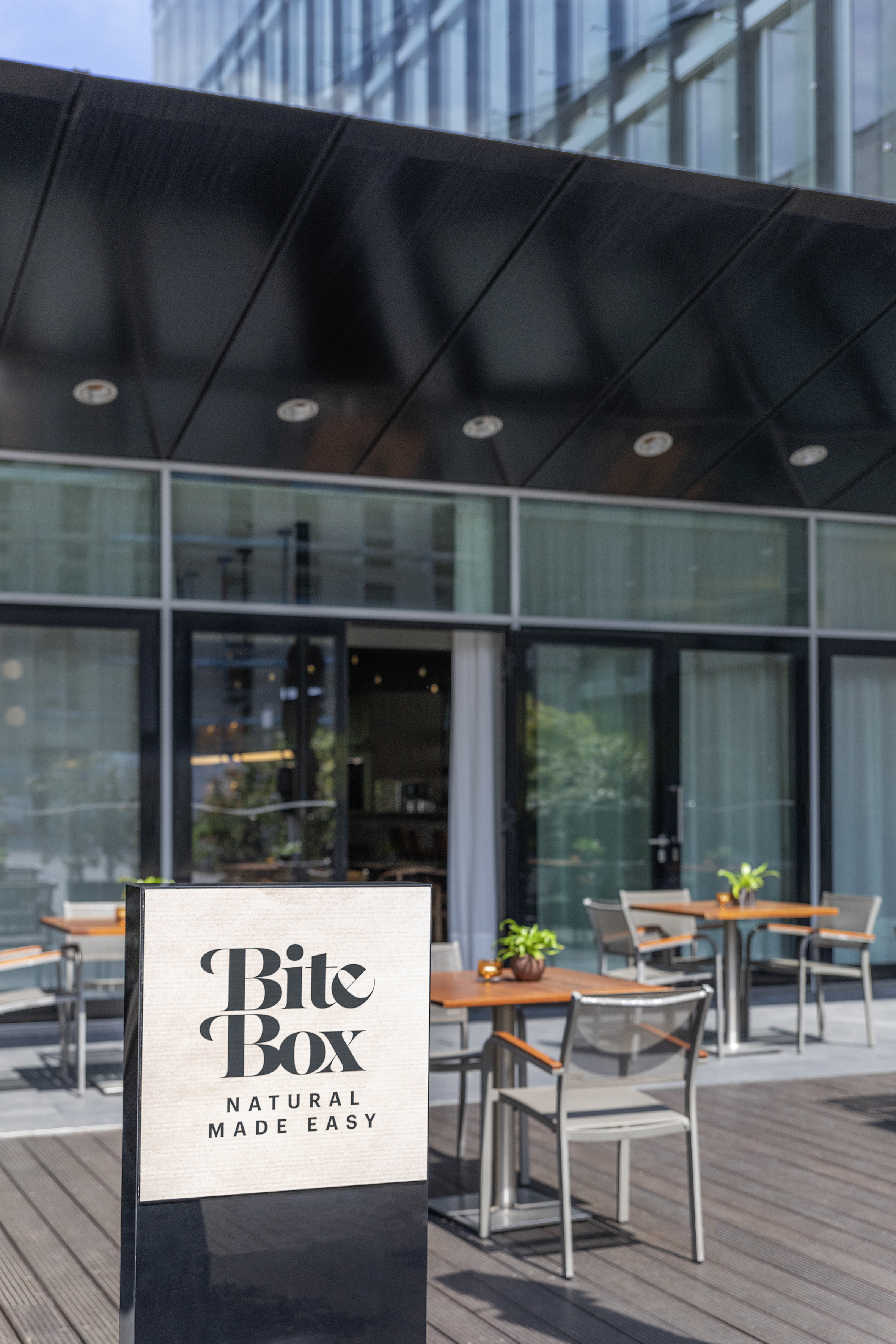 Bite Box Natural Made Easy sign outside modern cafe patio with outdoor seating.