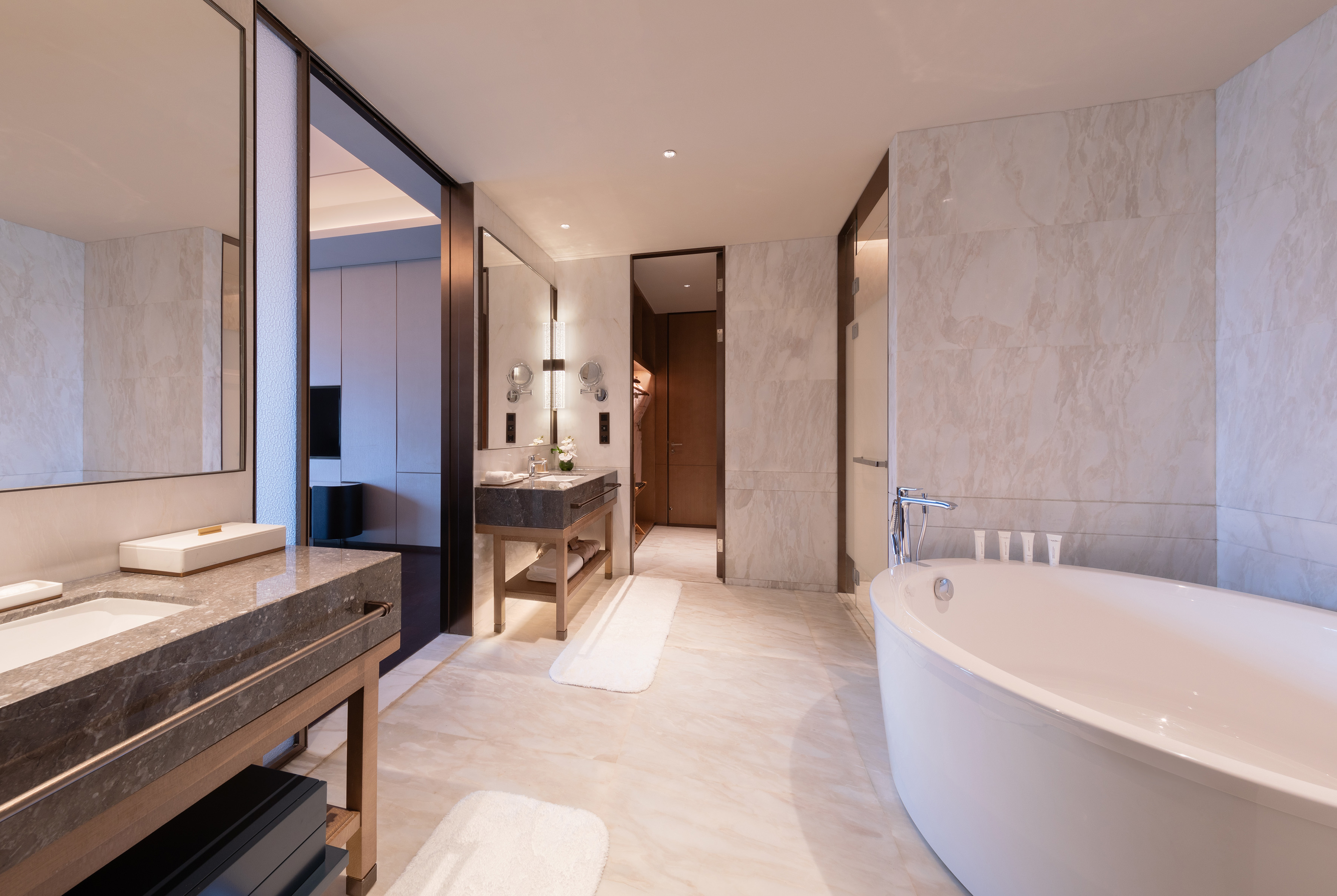 Luxurious hotel bathroom with freestanding tub, marble, and dual vanity.