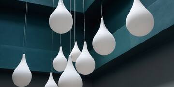 a group of white balloons from a ceiling