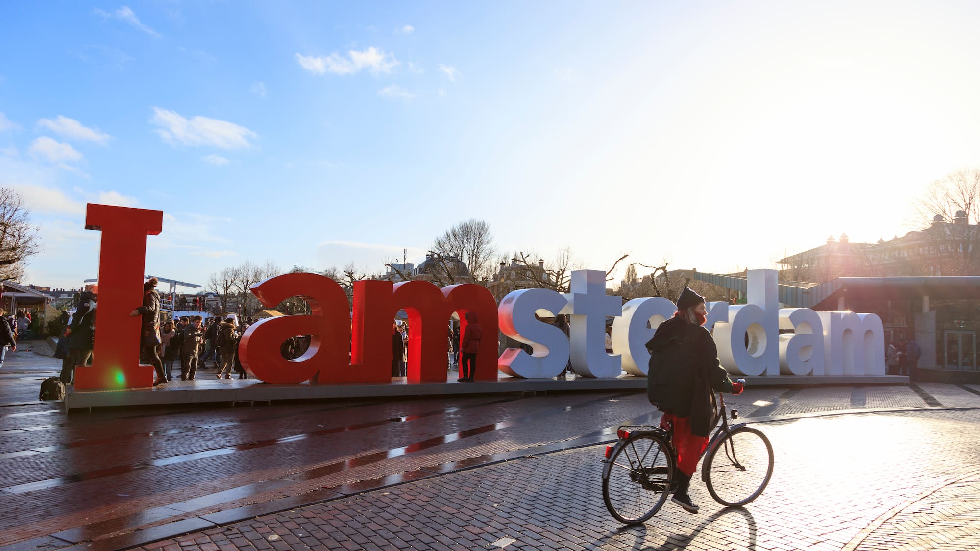 a man riding a bicycle on a brick road with large letters