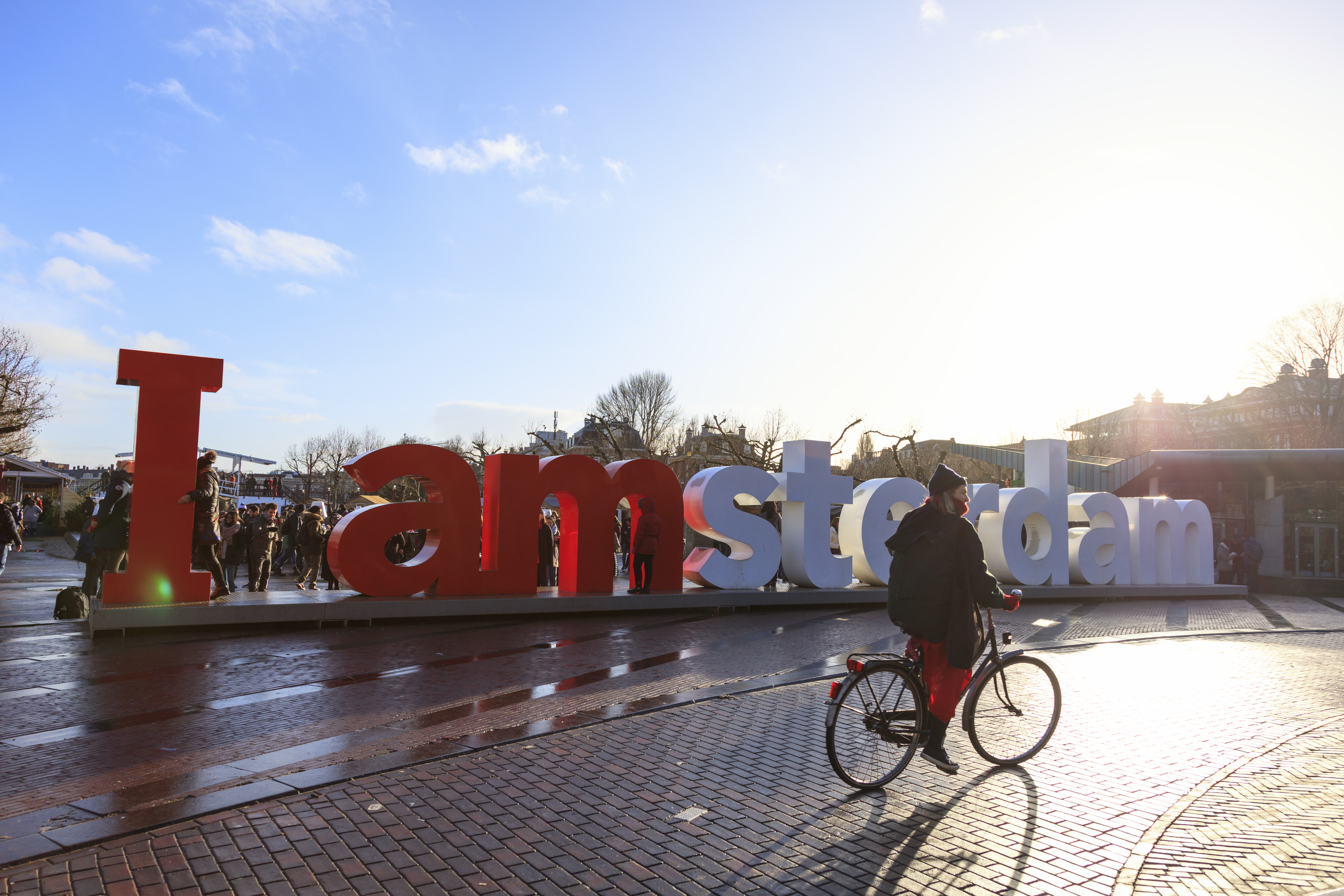a man riding a bicycle on a brick road with large letters