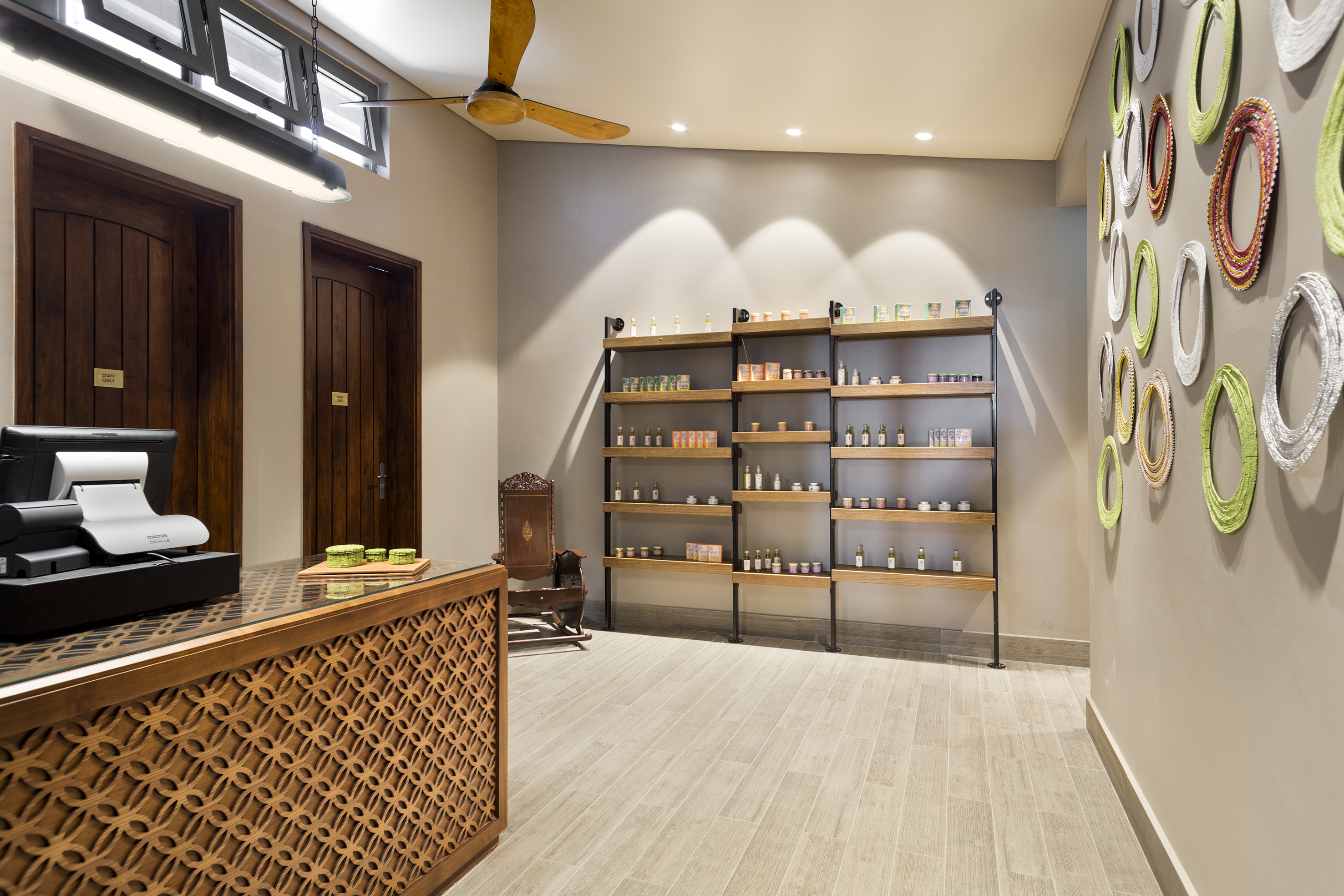 Boutique interior: wooden desk, product display shelves, and colorful wall decor.