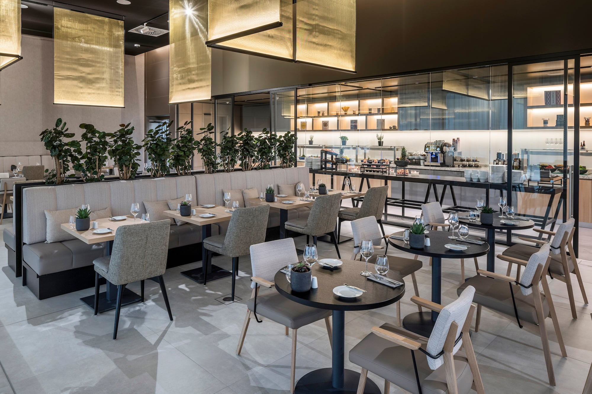 Contemporary hotel restaurant with elegant tables, booth seating, and buffet.