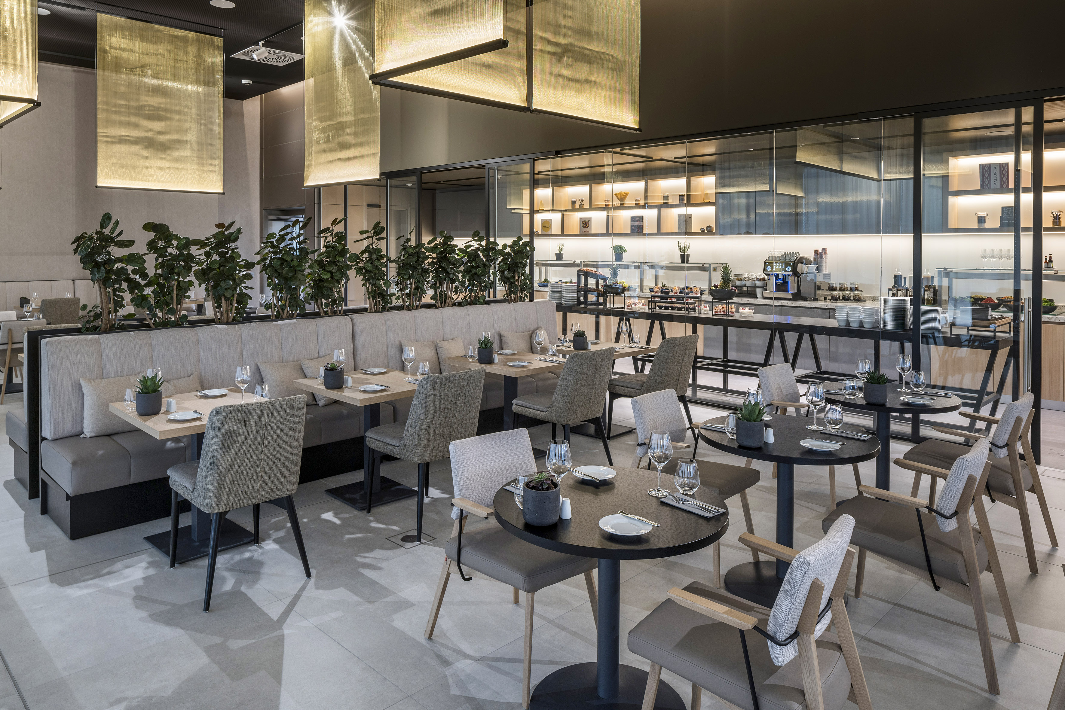 Contemporary hotel restaurant with elegant tables, booth seating, and buffet.