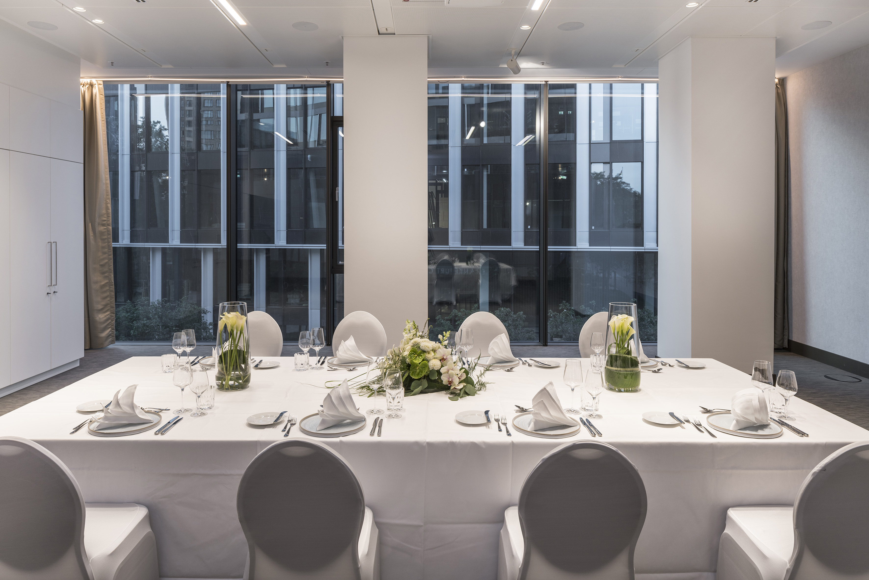 Modern event space with formal dining table and city views.