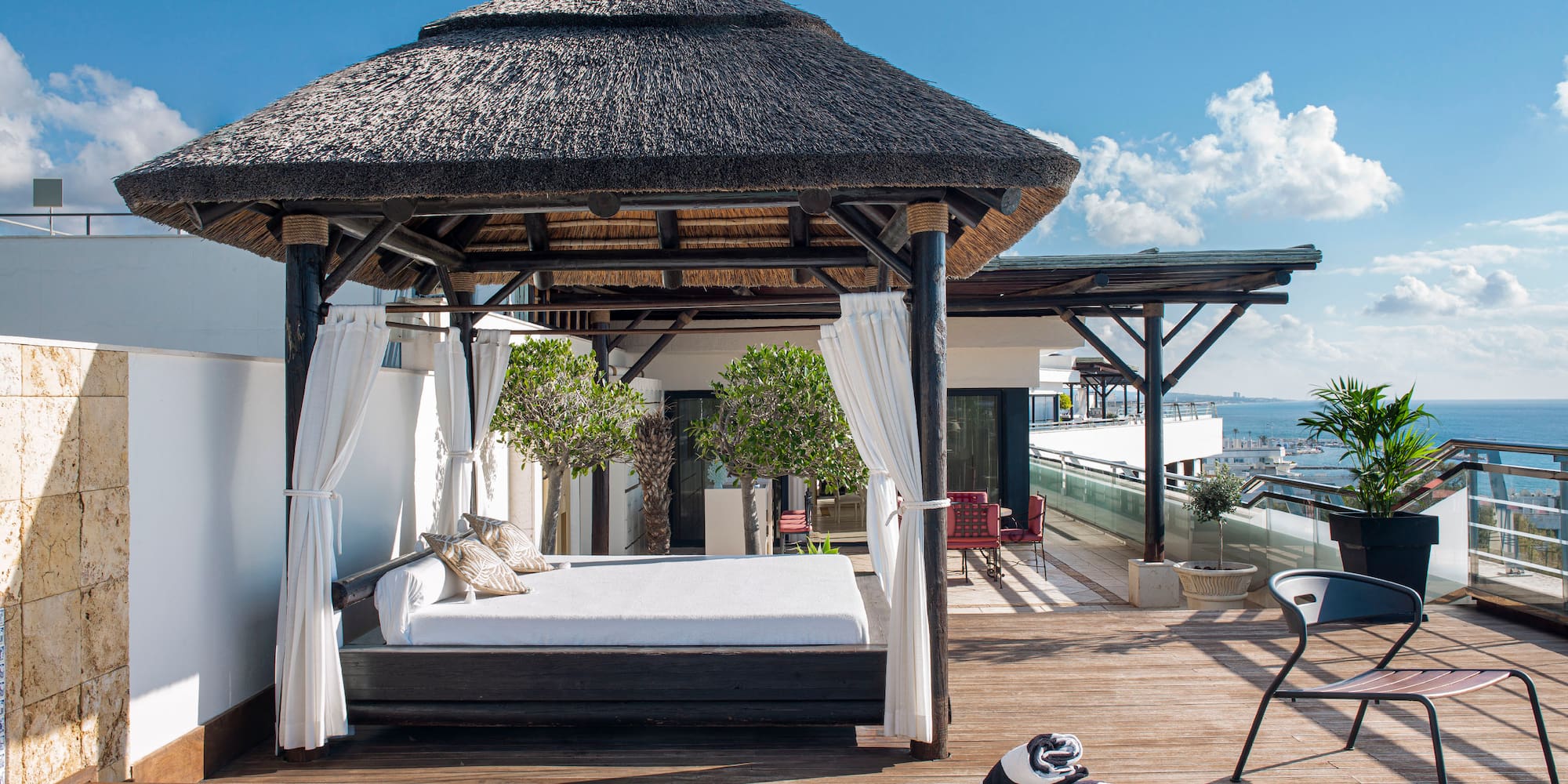 a pool with a bed and a chair on a deck