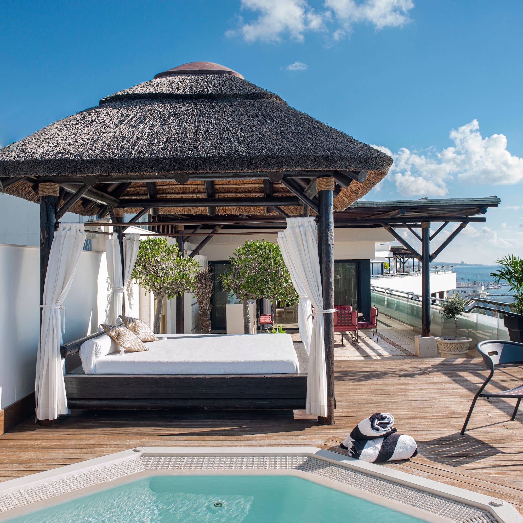 a pool with a bed and a chair on a deck