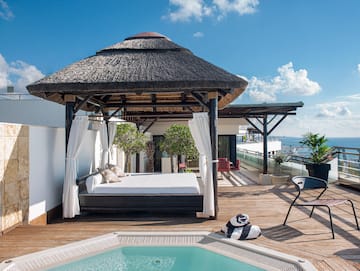 a pool with a bed and a chair on a deck