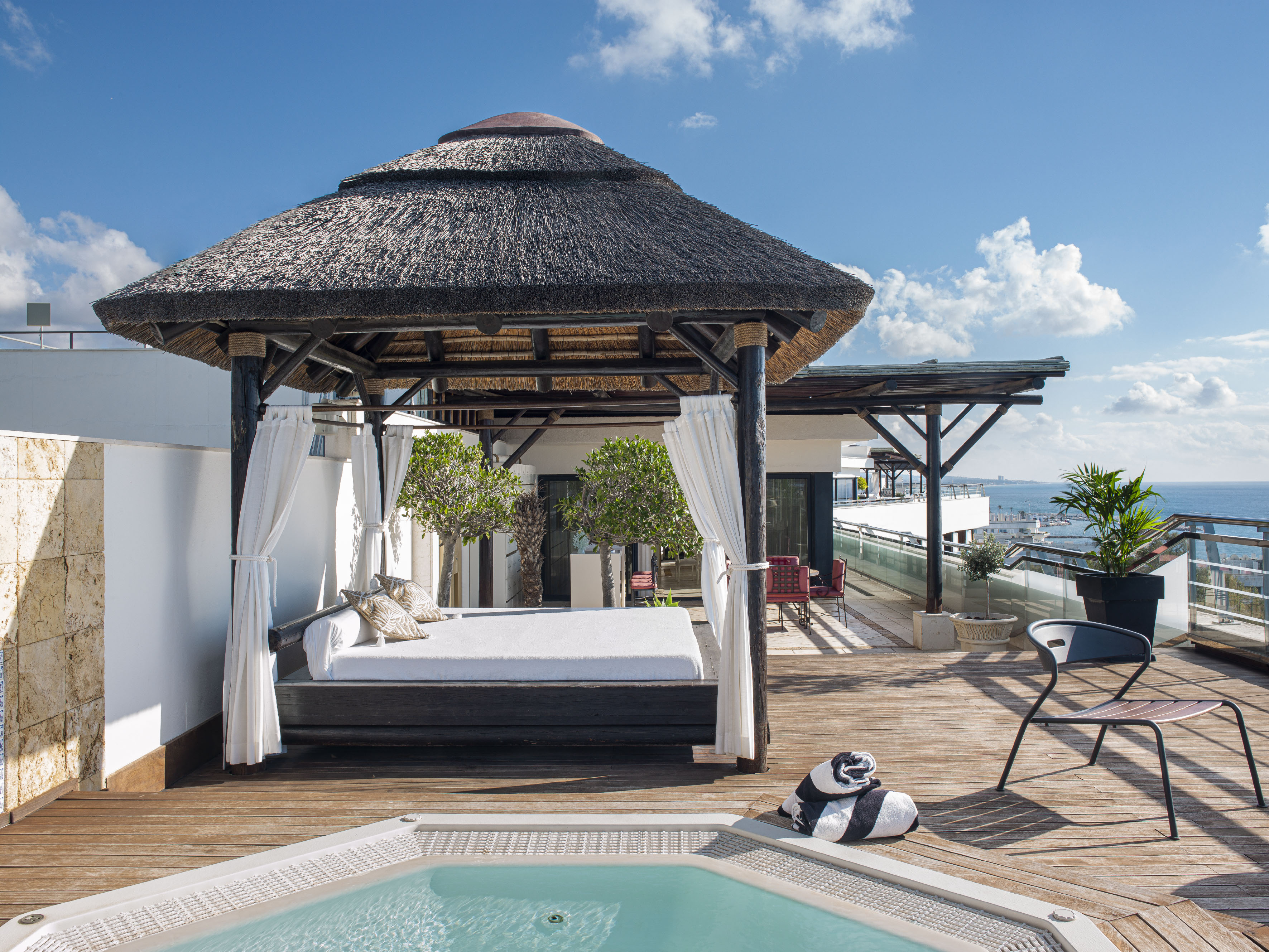 a pool with a bed and a chair on a deck