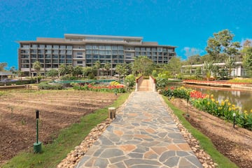 a stone path leading to a garden with a building in the background