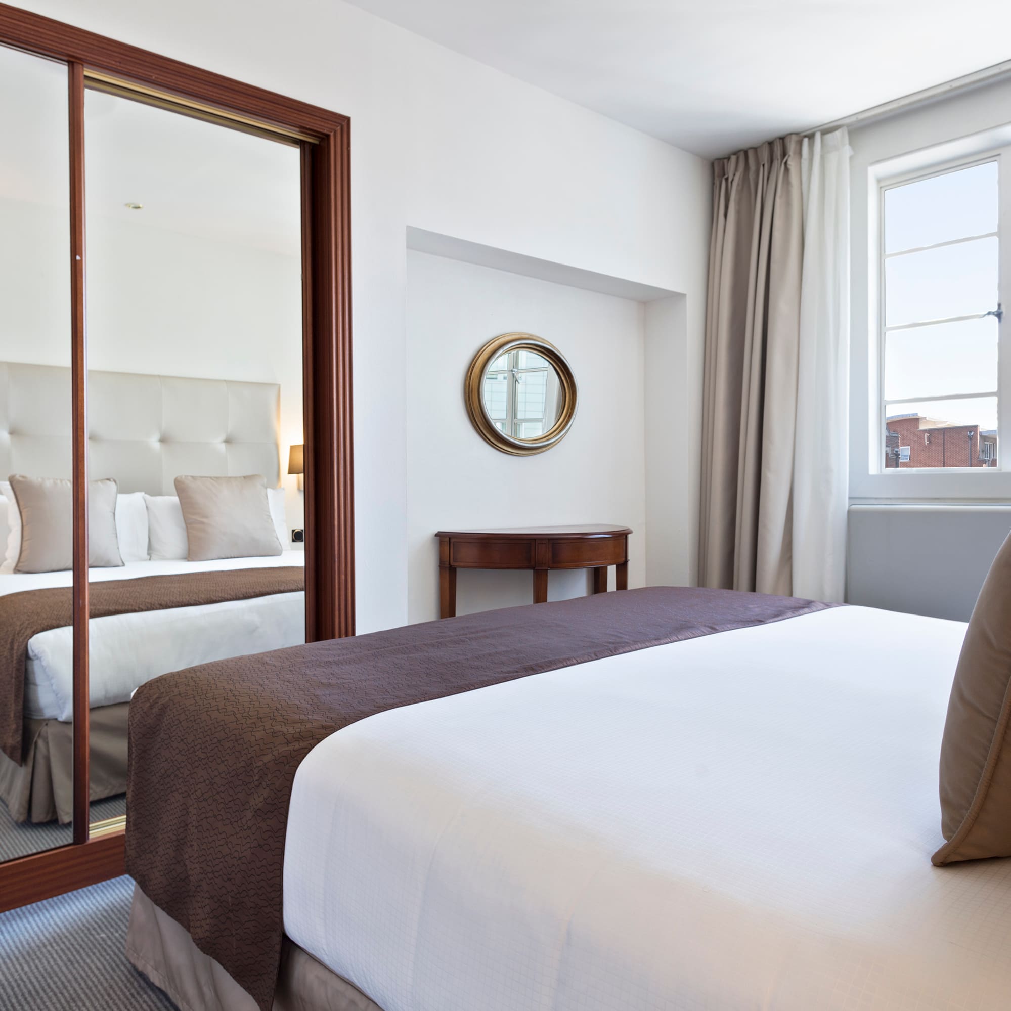 a bedroom with a mirror and a bed