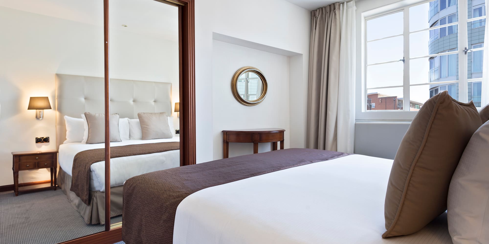 a bedroom with a mirror and a bed