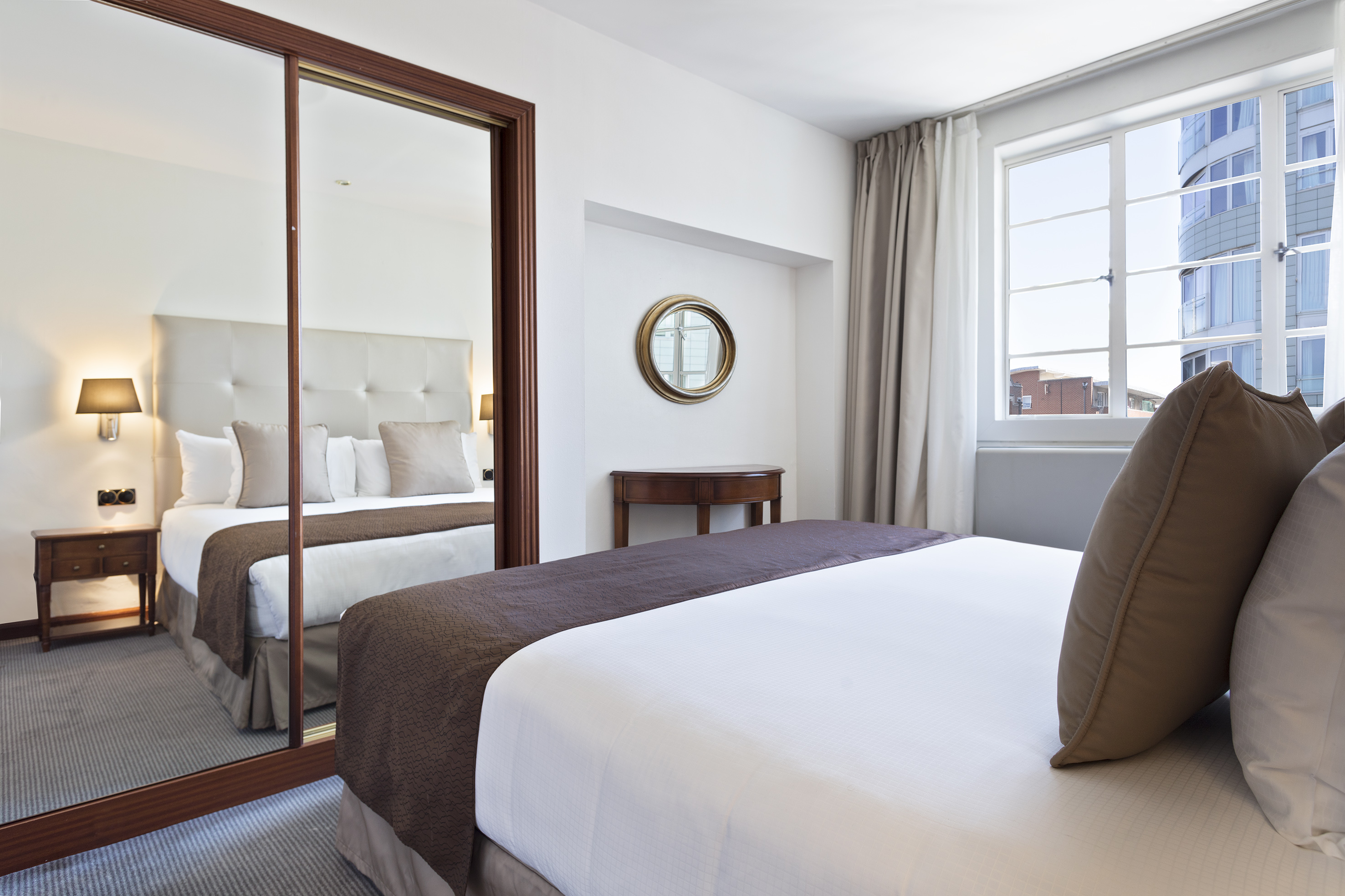 a bedroom with a mirror and a bed